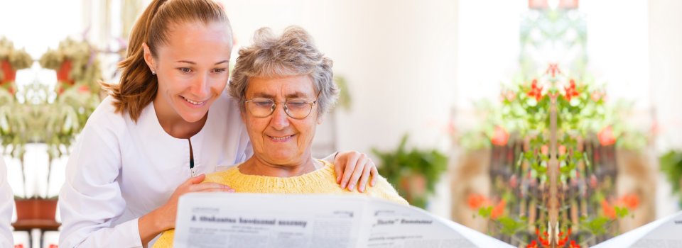 woman and elderly woman reading news